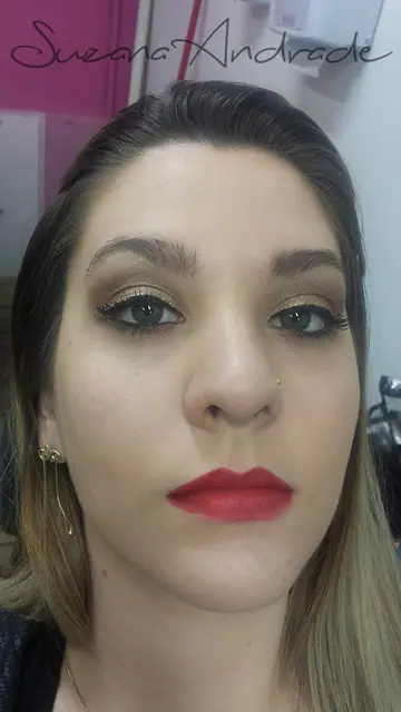 Maquiagem com olhos dourados e batom vermelho