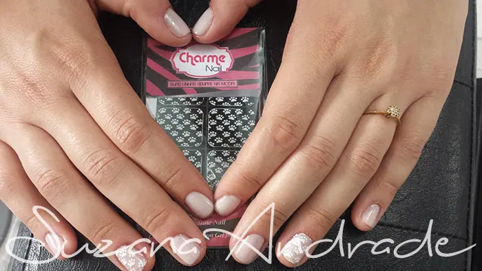 Mãos com unhas de esmalte claro e adesivos